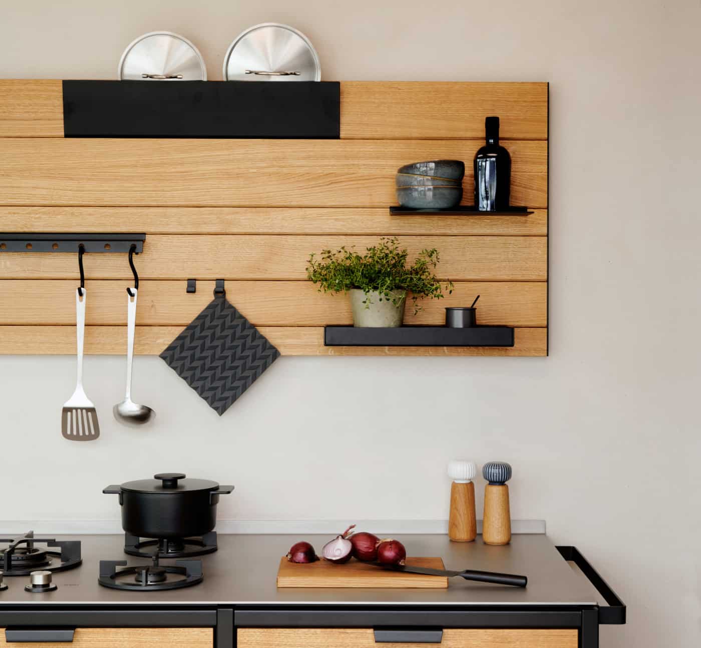 Frontansicht auf ein Regalsystem für die Küche: das TUUL Küchenboard ist bestückt mit unterschiedlichen Zubehör wie Talare und Behälter.